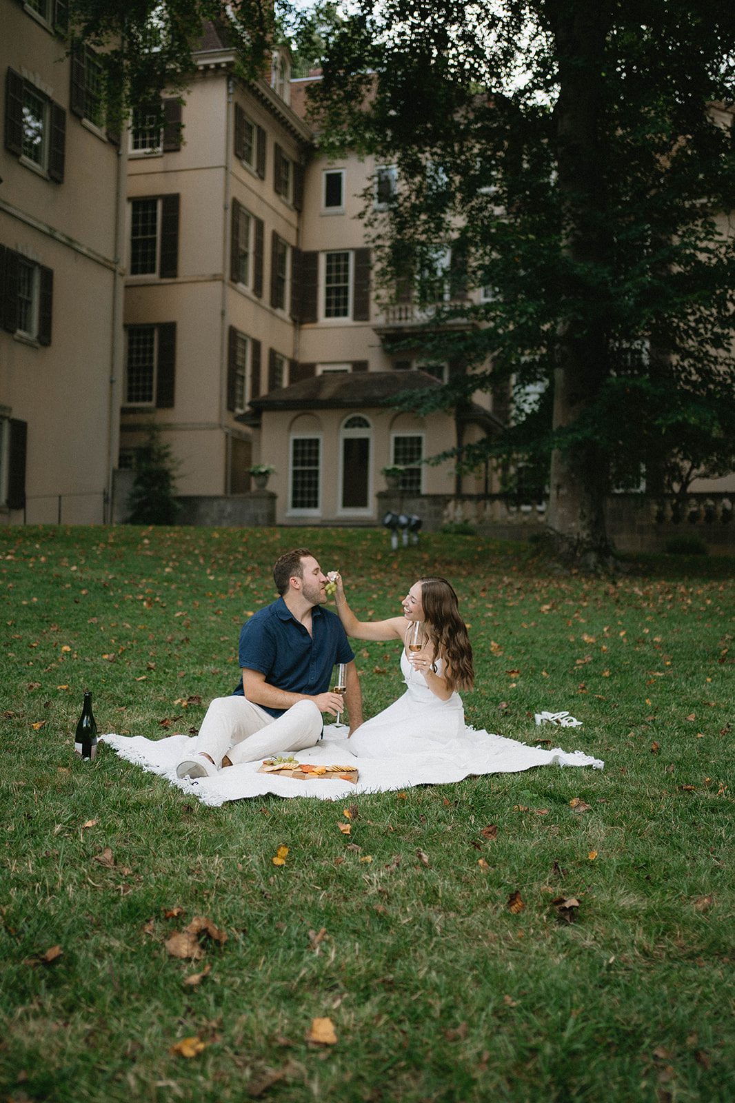 a couple having a picnic for their engagement session at Winterthur Gardens